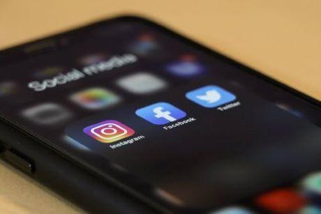Cellphone with icons of Instagram, Facebook, and Twitter on the screen