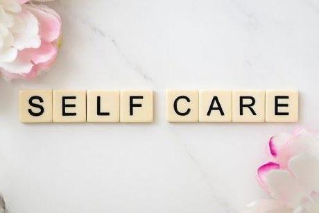 Self Care in letter tiles and 2 flowers